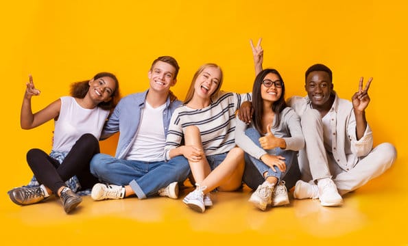 Young people putting up the peace sign.