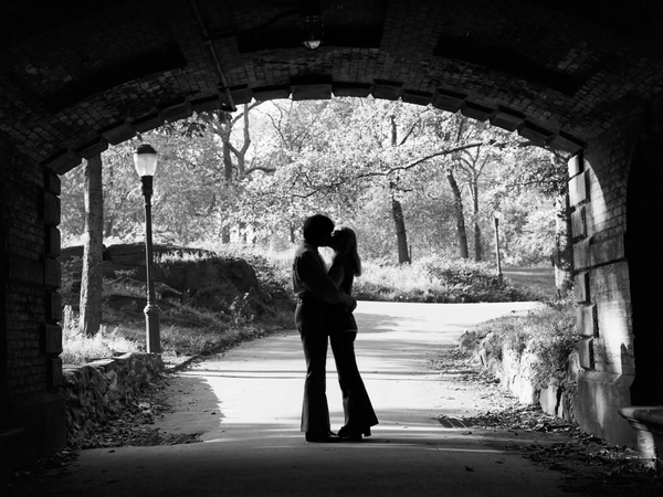 Couple kissing under a bridge in Central Park NYC.