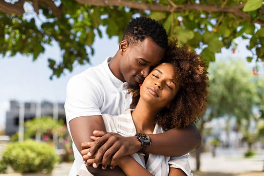 A couple sharing a loving embrace in the park.