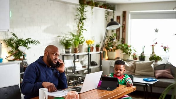 Dad working from home while watching his son.