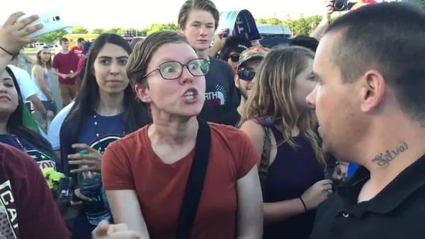 Feminist raging at a man for no reason at a rally.